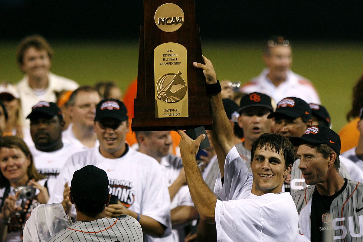 Mitch Canham, new Head Coach for the Beavers, holds up the championship trophy after winning it as a player.