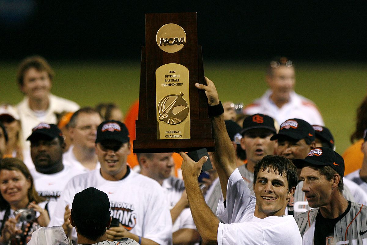 Mitch Canham, new Head Coach for the Beavers, holds up the championship trophy after winning it as a player.